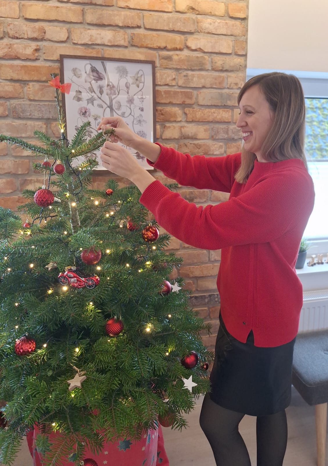 Frau schmückt einen Weihnachtsbaum